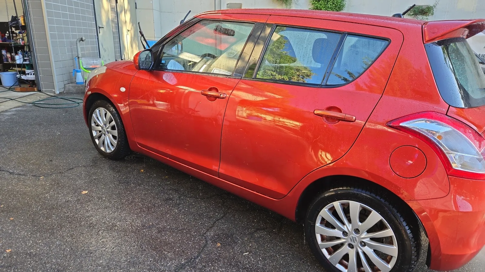 Roter Suzuki Swift mit Wasserperlen auf dem Lack